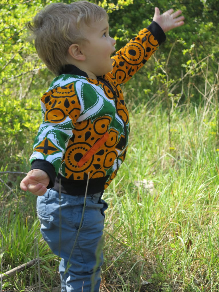 Bébé portant un bomber orange et vert